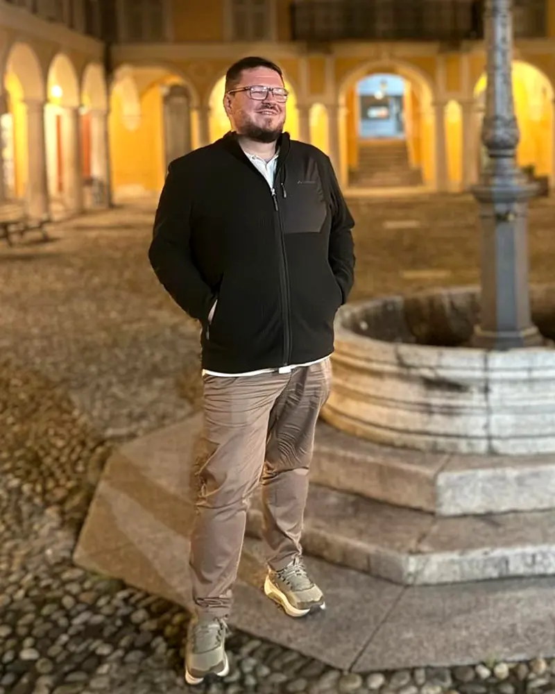 Patrick Storzum, abends in einem Arkadenhof